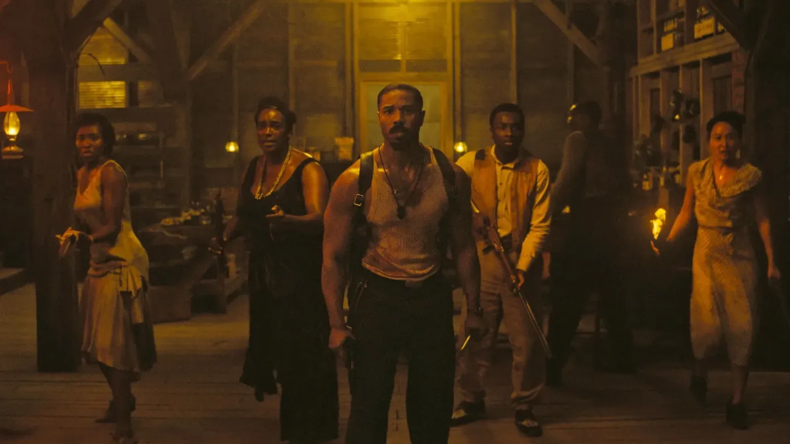 Cast of the film Sinners in a dramatic, dark-toned promotional image.