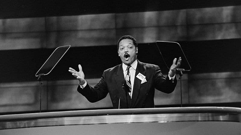 Jesse Jackson passionately speaking to a crowd during a civil rights rally